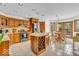 Bright kitchen featuring tile floors, wooden cabinets, a center island with wine rack and stainless appliances at 7113 Lakeside Woods Dr, Indianapolis, IN 46278