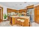 Spacious kitchen featuring a center island with seating, stainless refrigerator and wooden cabinetry at 7113 Lakeside Woods Dr, Indianapolis, IN 46278