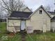 Exterior shot of a run-down house with boarded windows and a weathered door in need of repair at 727 W 25Th St, Indianapolis, IN 46208