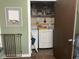 Open laundry room with washer and dryer, shelves for storage, and a safety gate at 760 E Walnut St, Martinsville, IN 46151