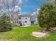 Serene backyard features a concrete patio with outdoor seating, mature trees, and lush green grass at 7775 Hollow Ridge Cir, Indianapolis, IN 46256