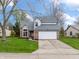 Attractive two-story home with brick facade, attached garage, manicured lawn and mature trees at 7775 Hollow Ridge Cir, Indianapolis, IN 46256