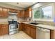 Functional kitchen with stainless steel appliances, wood cabinets, and a large sink at 7775 Hollow Ridge Cir, Indianapolis, IN 46256