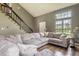Cozy living room featuring a large sectional sofa, hardwood floors, and staircase at 7775 Hollow Ridge Cir, Indianapolis, IN 46256
