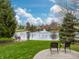 Scenic view of a neighborhood pond with a fountain, surrounded by lush greenery and mature trees at 7775 Hollow Ridge Cir, Indianapolis, IN 46256