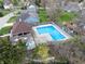 An aerial view of the community pool area, featuring lounge seating, a pool house, and mature trees at 7775 Hollow Ridge Cir, Indianapolis, IN 46256