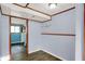 Hallway with light blue walls, plank floors, leading to another room with natural light at 7915 Broadview Dr, Indianapolis, IN 46227