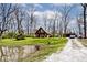 View of the house from the yard with a pond, gravel drive, and a detached garage at 8327 S County Road 825 E, Plainfield, IN 46168