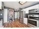 Updated kitchen boasts stainless steel appliances, white cabinets, hardwood flooring and pantry storage space at 8327 S County Road 825 E, Plainfield, IN 46168