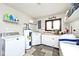Spacious laundry room with white cabinets, modern appliances and shelves for storage at 8327 S County Road 825 E, Plainfield, IN 46168