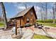 Back view of the house with a patio, seating area, fire pit, and a wooded yard at 8327 S County Road 825 E, Plainfield, IN 46168