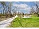View of pond on the property with a long gravel driveway and green grass at 8327 S County Road 825 E, Plainfield, IN 46168