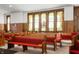 Close up interior view of traditional wooden pews with red cushions and prominent stained glass windows at 840 Cottage Ave, Indianapolis, IN 46203