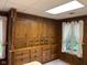 Finished basement area with built-in storage, wood paneling and a window at 8801 Ridge Hill Dr, Indianapolis, IN 46217