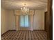 Dining room with ornate chandelier, neutral walls and bay window with decorative curtains at 8801 Ridge Hill Dr, Indianapolis, IN 46217