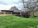 Sprawling home with tiered wooden decks, lush green lawn, stone details, mature trees, and partially visible chimney at 8801 Ridge Hill Dr, Indianapolis, IN 46217