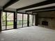 Spacious living room with beamed ceiling, sliding doors to deck and stone fireplace at 8801 Ridge Hill Dr, Indianapolis, IN 46217