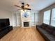 Cozy living room with a fireplace, built-in bookshelves, and large windows at 8859 Delaney Dr, Fishers, IN 46038
