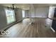 Spacious living room with large windows, light wood-look floors, and modern chandelier at 9218 Wind River Ct, Indianapolis, IN 46234