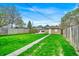 A lush backyard with green grass, wood fence, and a detached garage at 936 N Oxford St, Indianapolis, IN 46201