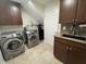 Laundry room featuring modern washer and dryer, cabinets, and sink at 10404 Trillium Ct, Noblesville, IN 46060