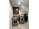 Laundry room equipped with side-by-side washer and dryer, cabinets, and water filtration system at 10404 Trillium Ct, Noblesville, IN 46060