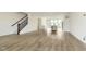 Open-concept living area featuring hardwood floors connecting kitchen and staircase at 10953 Belgian Ln, Zionsville, IN 46077