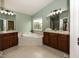 Bathroom featuring double sinks with wooden cabinets, a soaking tub, and neutral paint at 11648 Stickney Ct, Fishers, IN 46037