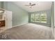 Spacious main bedroom featuring three large windows, neutral carpeting, and a ceiling fan at 11648 Stickney Ct, Fishers, IN 46037