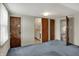 Attic with gray carpet and different doors, including a doorway to a bathroom at 1194 S Faculty Dr, Indianapolis, IN 46241
