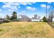 Backyard view of a stone-clad home with a large grassy area and detached garage at 1194 S Faculty Dr, Indianapolis, IN 46241