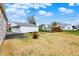 Backyard showcasing a detached garage, a glimpse of a deck, and a stone-clad house at 1194 S Faculty Dr, Indianapolis, IN 46241