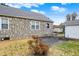 Backyard featuring a stone-clad house and a detached garage, complete with a spacious yard at 1194 S Faculty Dr, Indianapolis, IN 46241