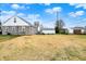 Backyard featuring a stone-clad house with a detached garage and expansive grassy area at 1194 S Faculty Dr, Indianapolis, IN 46241
