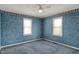 A bedroom featuring floral wallpaper, ceiling fan, and two windows at 1194 S Faculty Dr, Indianapolis, IN 46241
