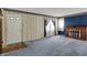 Cozy living room featuring a brick fireplace, patterned wallpaper, and blue carpet at 1194 S Faculty Dr, Indianapolis, IN 46241