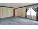 Spacious living room featuring patterned wallpaper, blue carpet, and a front door at 1194 S Faculty Dr, Indianapolis, IN 46241