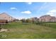 Large, green backyard with lush lawn, black fence, and neighborhood view, great for recreation at 1243 Colinbrook Cir, Greenwood, IN 46143