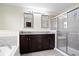 Bathroom with a double vanity, sleek dark cabinets, and a glass-enclosed shower with modern fixtures at 1243 Colinbrook Cir, Greenwood, IN 46143