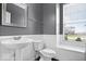 Bathroom featuring a pedestal sink, large window, white wainscotting, and modern fixtures at 1243 Colinbrook Cir, Greenwood, IN 46143