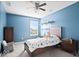 Blue bedroom featuring a wooden bed, a ceiling fan, carpeted floors, and large window at 1243 Colinbrook Cir, Greenwood, IN 46143