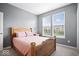 Comfortable bedroom featuring a wooden bed frame and large windows with natural light at 1243 Colinbrook Cir, Greenwood, IN 46143