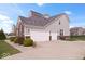 Exterior elevation showcasing a three car garage, brick accents, and a well-maintained lawn at 1243 Colinbrook Cir, Greenwood, IN 46143