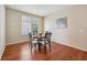 Bright dining area features wood floors, a round glass table, and natural light from the window at 12907 Shiraz Ln, Fishers, IN 46037