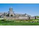 Community entrance featuring stone walls, manicured landscaping, and a clock tower at 12907 Shiraz Ln, Fishers, IN 46037