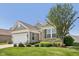 Charming home exterior with a two-car garage, brick accents, and lush green lawn at 12907 Shiraz Ln, Fishers, IN 46037