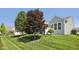 Well-maintained home exterior with manicured lawn, mature trees, and a charming facade at 12907 Shiraz Ln, Fishers, IN 46037