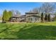 Expansive backyard featuring lush green grass, a wooden deck, gazebo, and mature trees at 13892 Adios Pass, Carmel, IN 46032