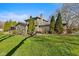 View of a green backyard with mature trees and a deck with an outdoor gazebo, perfect for summer gatherings at 13892 Adios Pass, Carmel, IN 46032