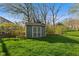 Backyard shed perfect for lawn equipment storage surrounded by a green lawn and budding trees at 13892 Adios Pass, Carmel, IN 46032